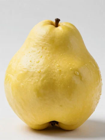 Cijela i narezana dunja na drvenoj površini, sa zelenim lišćem