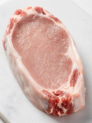 Svježi komadi teletine svijetle boje sa začinima na drvenoj dasci