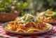 Chilaquiles s mesom enchilada, trakice tortilje, enchilada umak, piletina, avokado, sir i korijander kao ukras