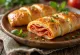 Stromboli s feferonima serviran, s bogatim feferonima i otopljenom mozzarellom na vrhu, izvana hrskav, a iznutra mekan.