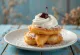 Talijanske krafne zeppole punjene šlagom i ukrašene višnjom