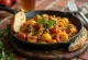 Chakalaka s curry začinom, poslužena s bogatim povrćem i začinima, ukrašena svježim korijanderom