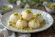 Rasgulla ukrašena pistacijama, poslužena na elegantnom tanjuru.