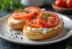 Bagel s rajčicom i krem sirom, ukrašen svježim bosiljkom