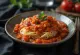 Paprika s umakom od rajčice, ukrašena svježim bosiljkom, jednostavno i primamljivo jelo